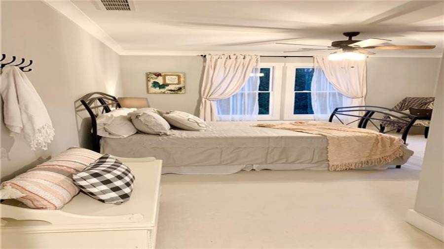 Oversized bedroom 5 is flooded in natural light from 3 windows overlooking side and rear of home
