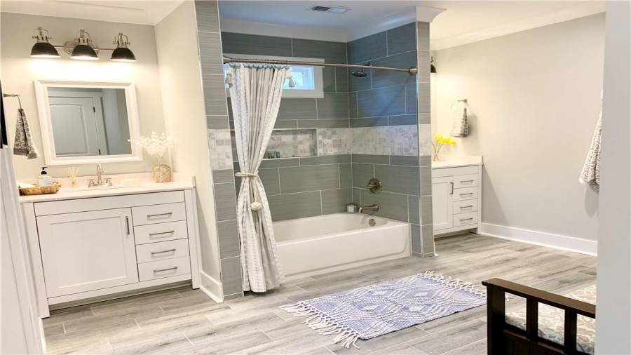 Enormous Jack & Jill bath offers 2 vanity cabinets, gorgeous tub & floor tile, & separate toilet closet