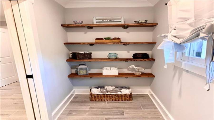 Custom wood shelves provide great storage across from toilet in jack & jill bath