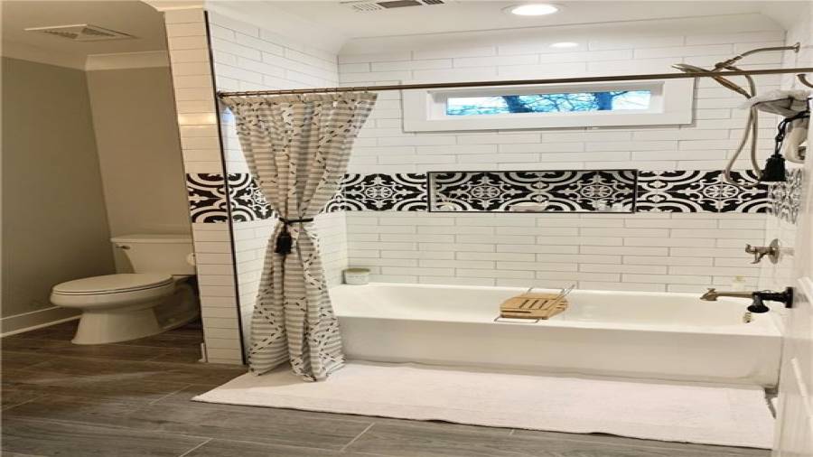 Lovely tub & floor tile in bath 4.  Stylish brushed gold plumbing & light fixtures