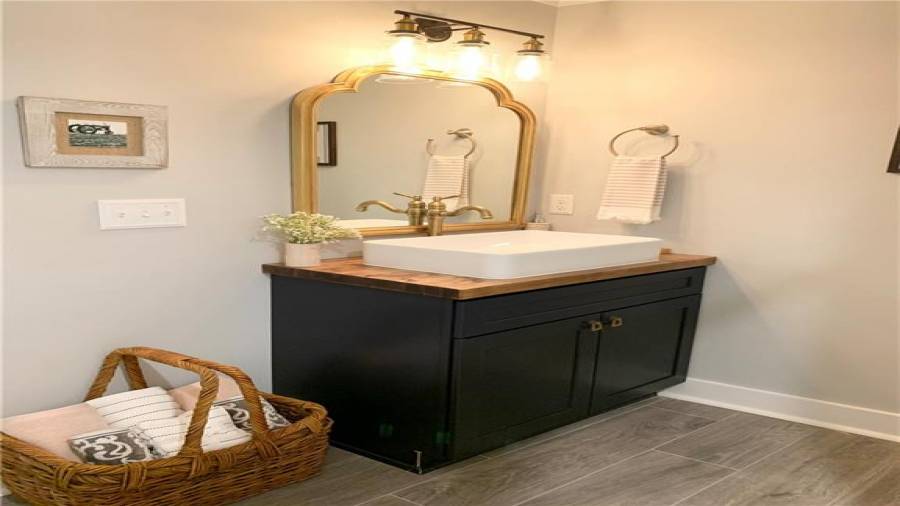 Incredible vanity cabinet with wood top & large vessel sink. Gorgeous mirror & vanity light!