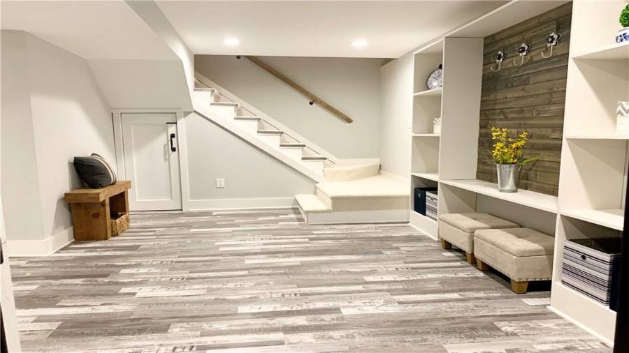 Super spacious mud room off one of the garages offers custom built-in mud room cabinet & extra storage space under staircase