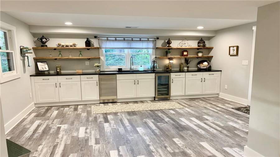 Wall to wall base cabinets with black granite counters, oversized SS sink, & custom wood shelving!  Built-in Icemaker and beverage cooler!!