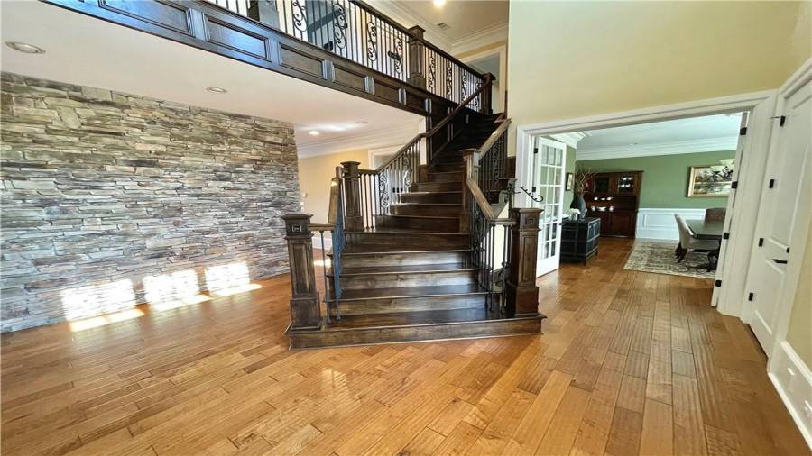 Stunning two-story entry foyer with the rock accent wall that greets you through the front doors.