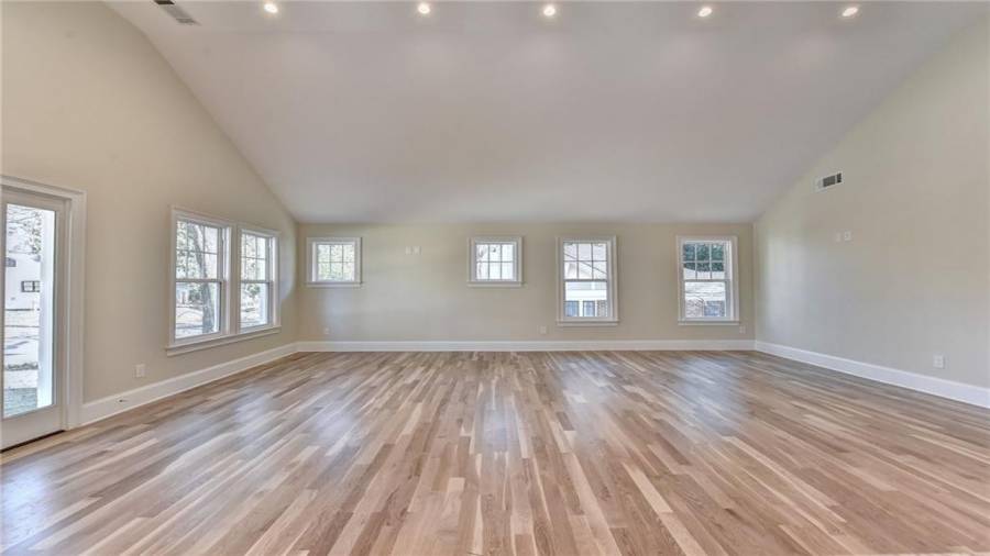 High vaulted family room with new windows gives lots of natural light throughout, new white oak flooring and designer lighting,