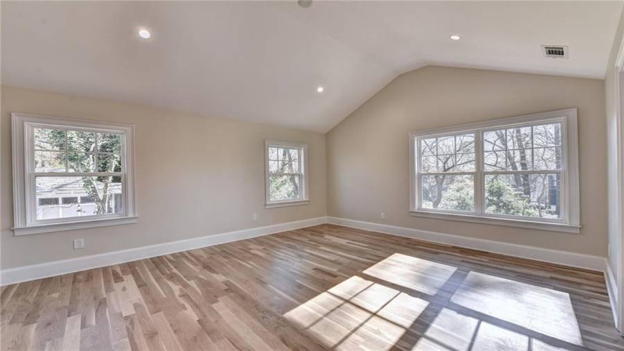 Master retreat on main level features a spacious bedroom with high vaulted ceiling, lots of new windows, white oak flooring, space saving pocket doors