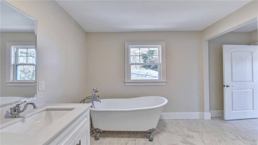 Cast iron clawfoot tub has classic telephone faucet with handheld shower combo