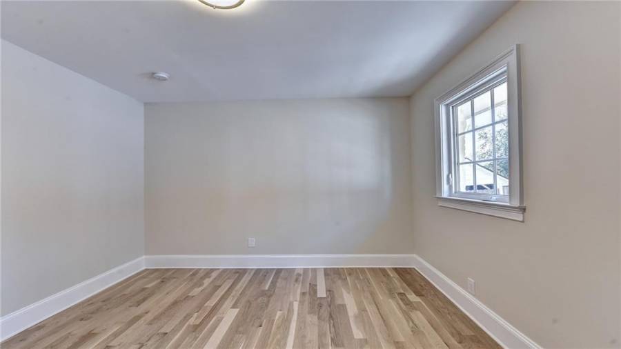 Guest bedroom on main level with new white oak flooring and windows