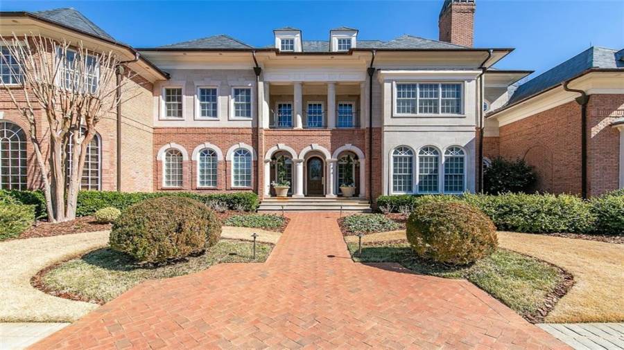 Grand entry with meticulous landscaping and natural gas outdoor sconces.