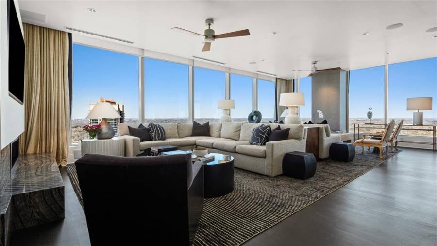 The Sunset and Buckhead Skyline Facing Den is 17 x 29 and Offers Stunning Views Of Buckhead and Midtown. Note Two Seating Areas and The Natural Gas Fireplace. The Kitchen Opens to This Space for A Casual Family Lifestyle And Effortless Entertaining.