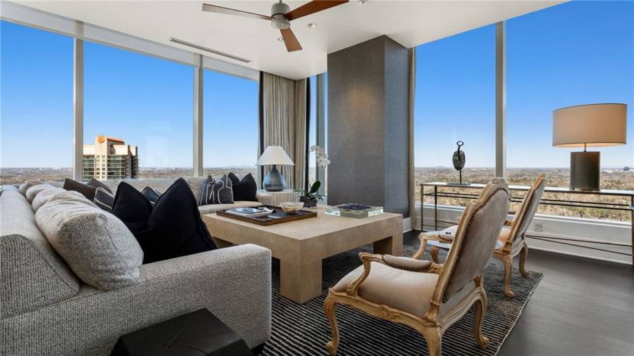 The Sunset and Buckhead Skyline Facing Den is 17 x 29 and Offers Stunning Views Of Buckhead and Midtown. Note Two Seating Areas and The Fireplace. The Kitchen Opens to This Space for A Casual Family Lifestyle And Effortless Entertaining.