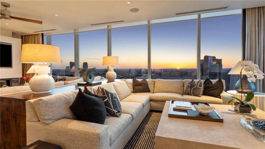 The Sunset and Buckhead Skyline Facing Den is 17 x 29 and Offers Stunning Views Of Buckhead and Midtown. Note Two Seating Areas and The Fireplace. The Kitchen Opens to This Space for A Casual Family Lifestyle And Effortless Entertaining.