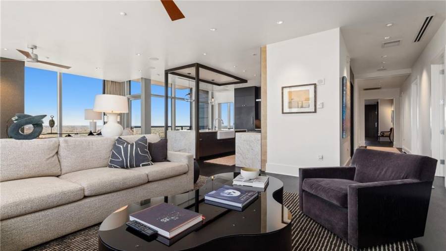 The Sunset and Buckhead Skyline Facing Den is 17 x 29 and Offers Stunning Views Of Buckhead and Midtown. Note Two Seating Areas and The Fireplace. The Kitchen Opens to This Space for A Casual Family Lifestyle And Effortless Entertaining.