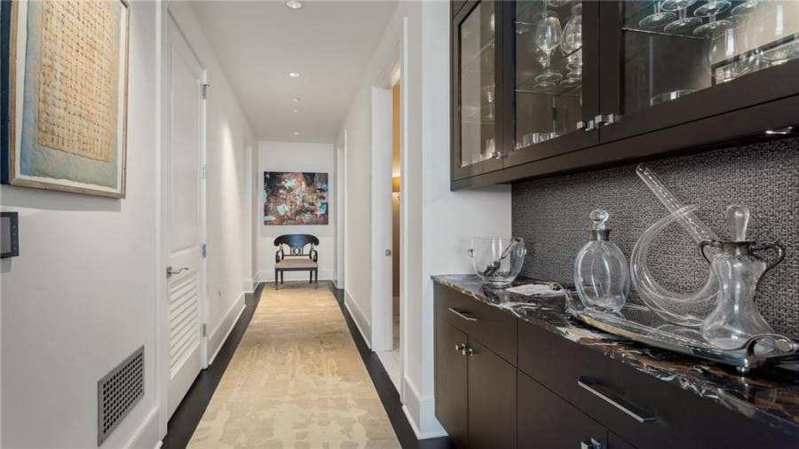 Hallway Leading To Powder Room, Secured Access Staff Delivery/Package Room and Bar. The Master Bedroom and Secondary Guest Suite Are To The Left - At The End Of The Hall.