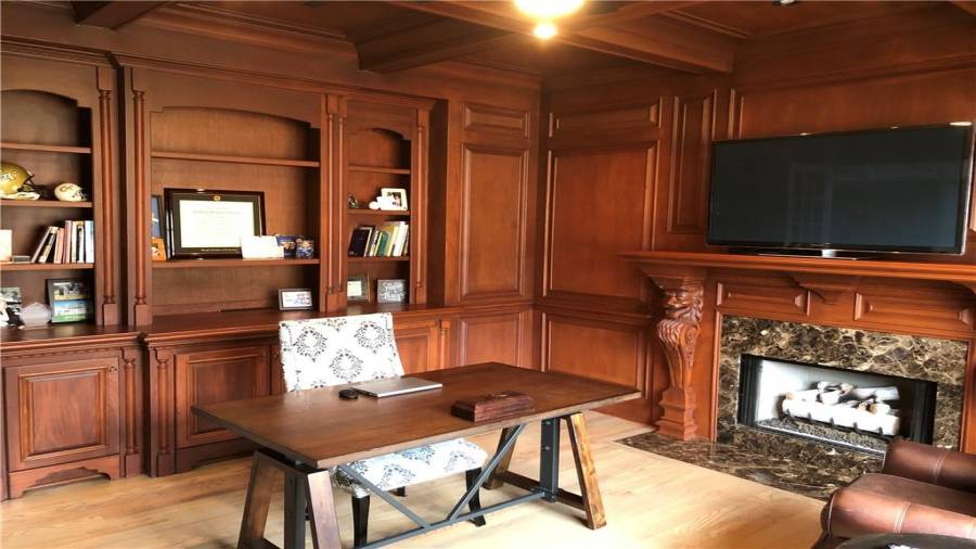 Beautiful wood paneled office/library with gas log fireplace.